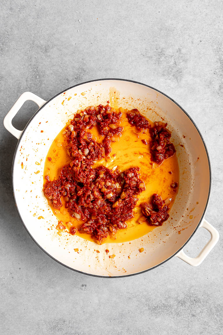 Tomato paste cooking a dutch oven to make sauce.