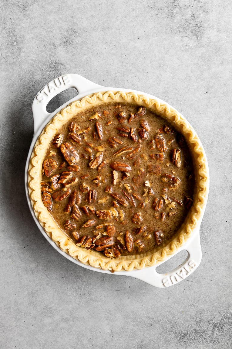 Pecan pie filling poured into a pie crust.