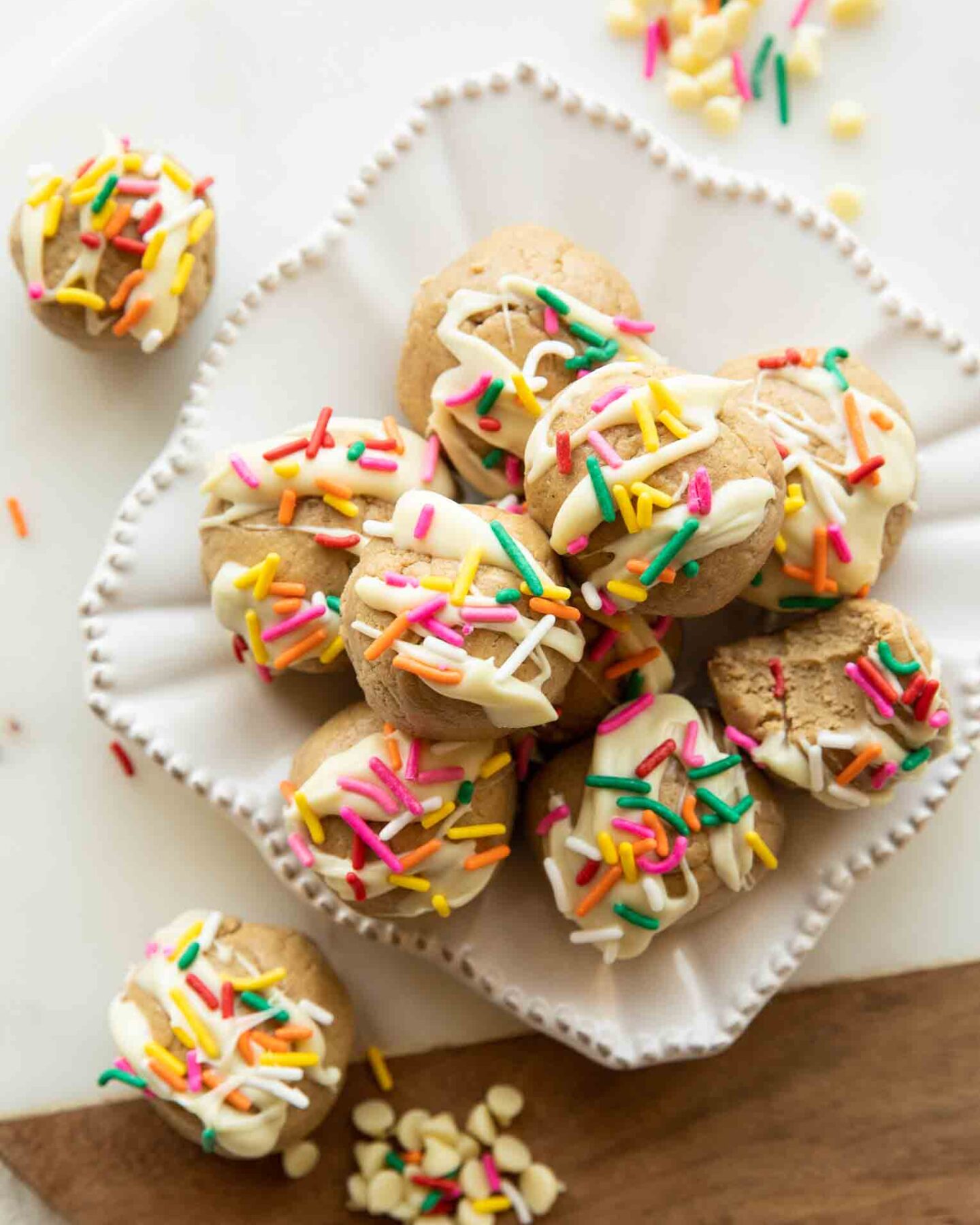 Birthday cake energy bites with white chocolate and sprinkles on a plate.