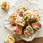 Birthday cake energy bites with white chocolate and sprinkles on a plate.