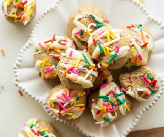 Birthday cake energy bites with white chocolate and sprinkles on a plate.
