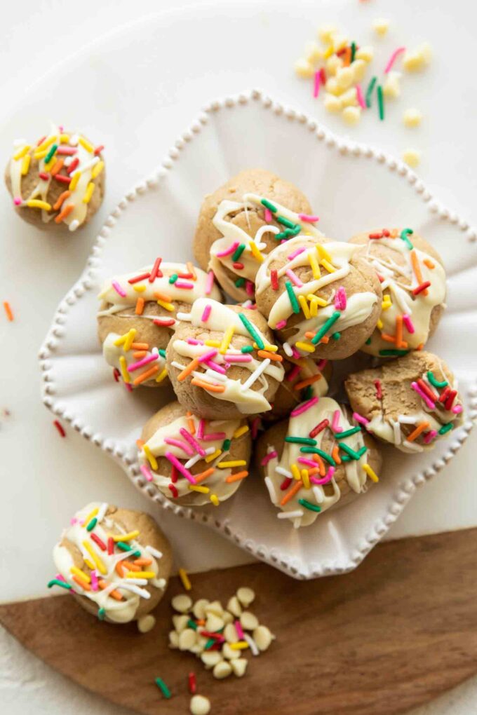 Birthday cake energy bites with white chocolate and sprinkles on a plate.
