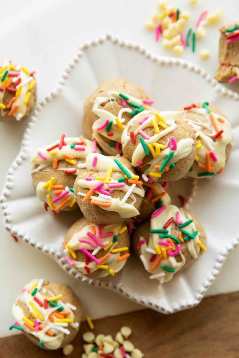 Birthday Cake Protein Bites stacked on a plate.