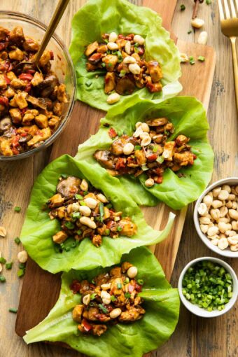 Healthy Thai Chicken Lettuce Wraps recipe on a wood cutting board.