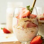 Strawberry Cheesecake Overnight Oats with fresh strawberries in a glass.