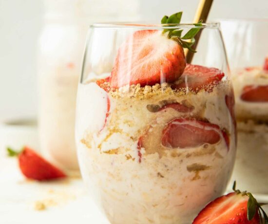 Strawberry Cheesecake Overnight Oats with fresh strawberries in a glass.