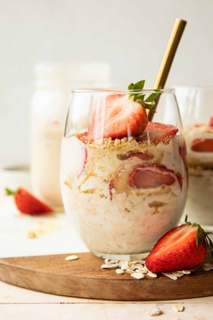 Strawberry Cheesecake Overnight Oats with fresh strawberries in a glass.