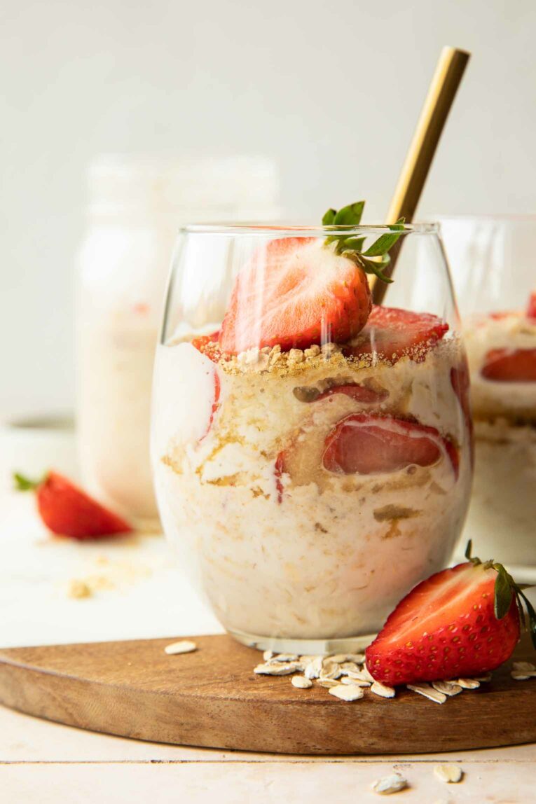 Strawberry Cheesecake Overnight Oats with fresh strawberries in a glass.
