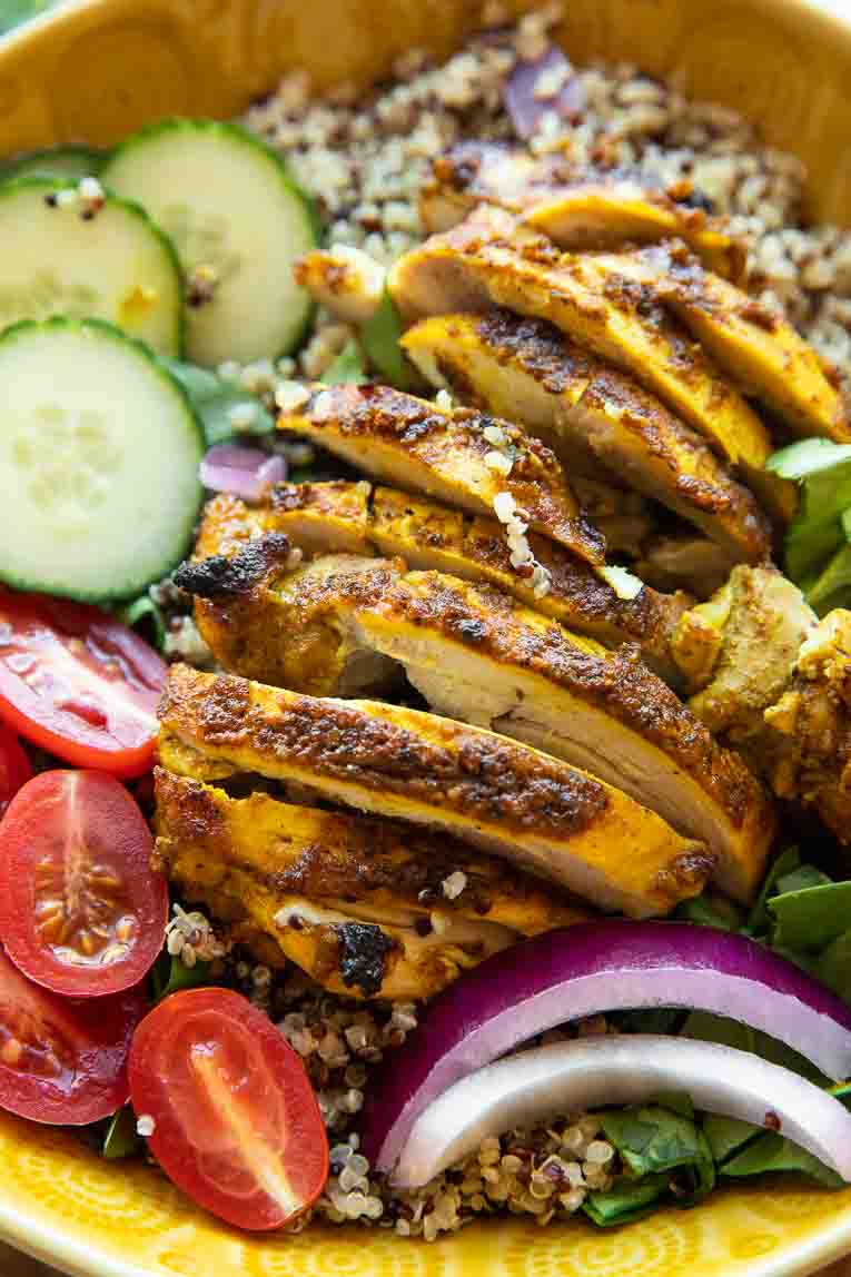 Sliced chicken shawarma over a mediterranean bowl.