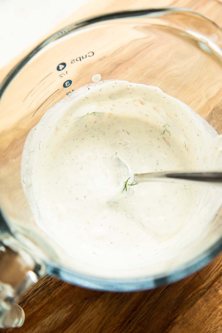 Tzatziki yogurt sauce being mixed together.