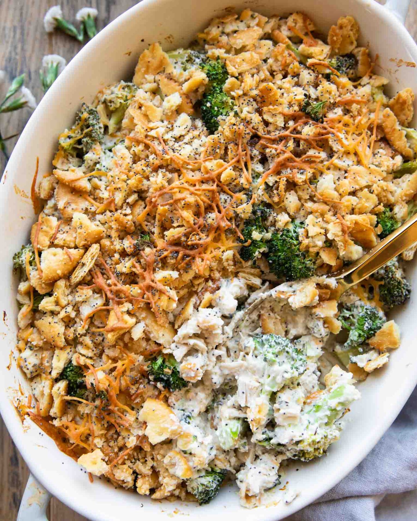 Poppy seed chicken casserole recipe with a spoon in casserole dish.