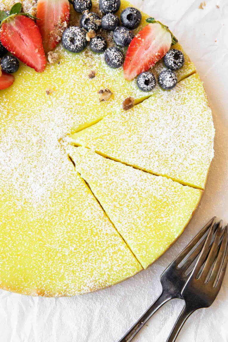 Close up of sliced vegan lemon tart with berries.