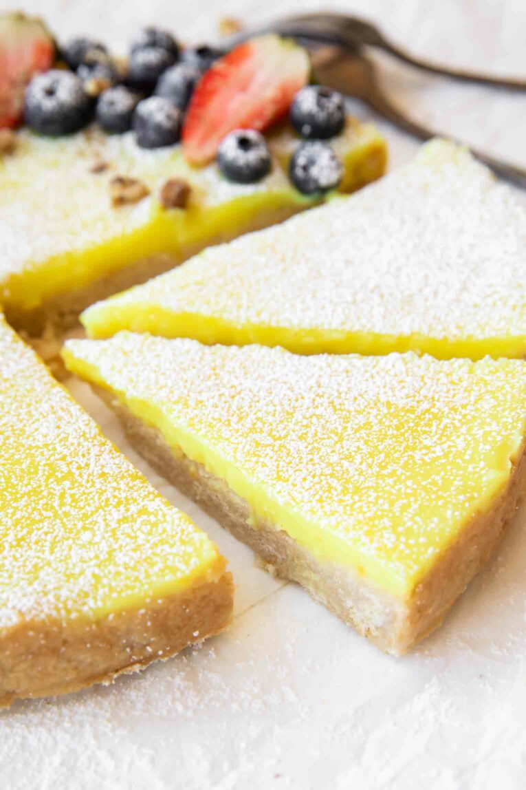 Angled photo of two slices of lemon curd tart.