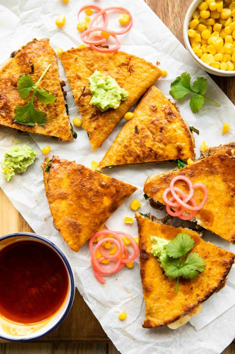 Birria Quesadillas slices with guacamole and radish.
