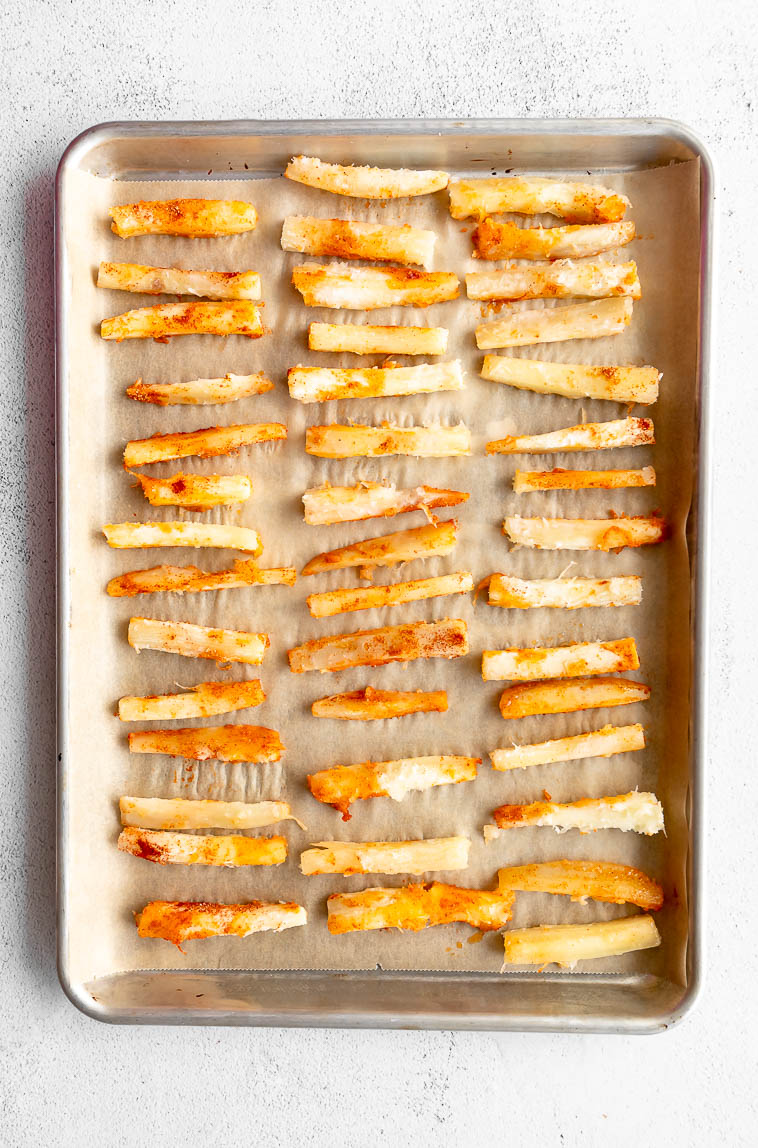 Yuca root in a flat layer on a baking sheet.