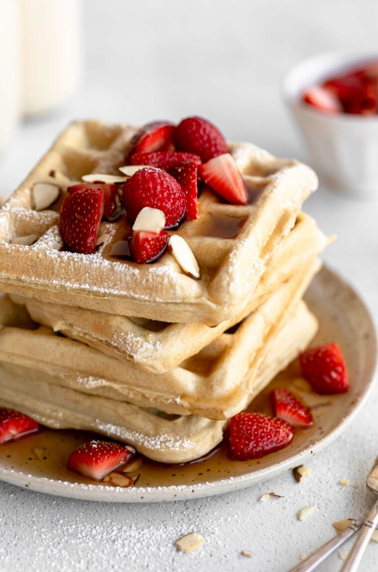 Stack of Gluten-Free Waffles with berries and syrup.