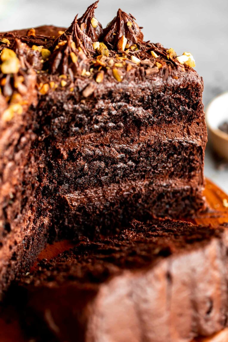 Whole Gluten-Free Chocolate Cake with Tahini-Chocolate Icing with slice taken out.