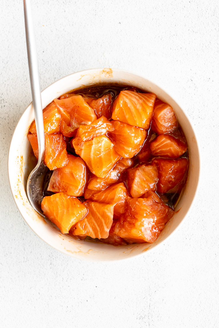 Honey glazed salmon in a bowl with sauce ingredients.