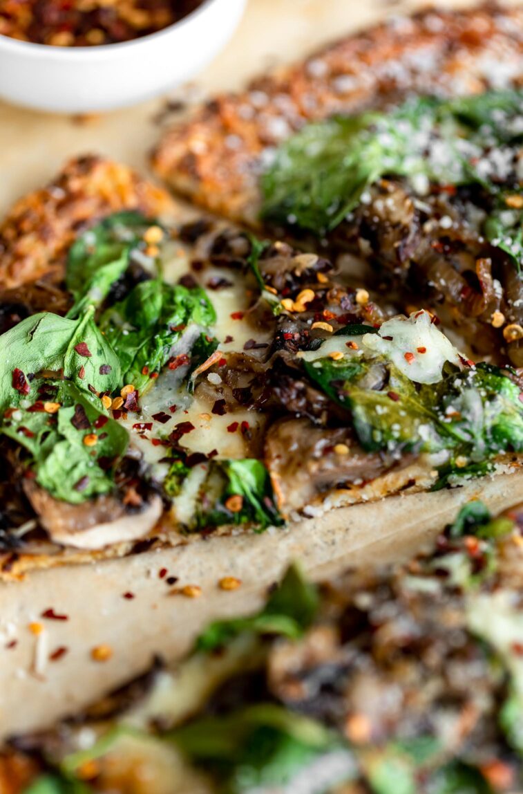 Angled photo of mushroom cauliflower pizza slice.