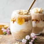 Banana Coconut Cream Pie Overnight Oats recipe on a wood board.