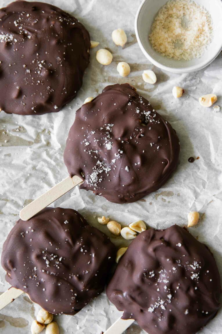 Buster bars on parchment paper with peanuts.