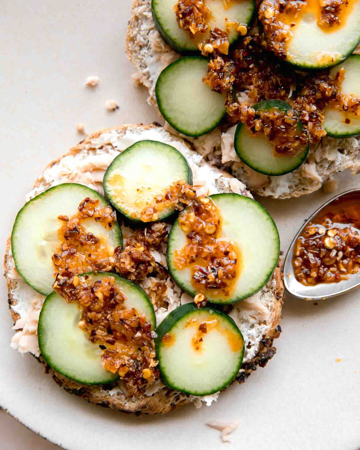 Chili Crunch Salmon Cream Cheese Bagel with chili crunch on a spoon.
