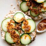 Chili Crunch Salmon Cream Cheese Bagel with chili crunch on a spoon.