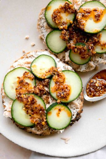 Chili Crunch Salmon Cream Cheese Bagel with chili crunch on a spoon.