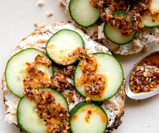 Chili Crunch Salmon Cream Cheese Bagel with chili crunch on a spoon.