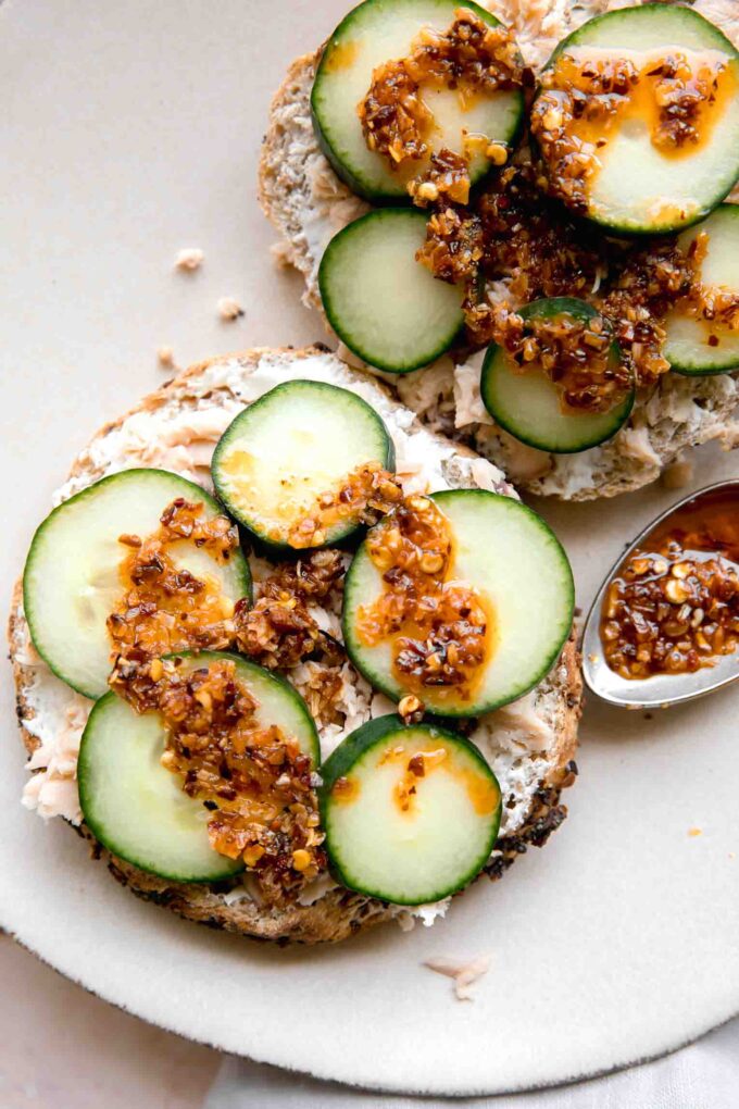 Chili Crunch Salmon Cream Cheese Bagel with chili crunch on a spoon.