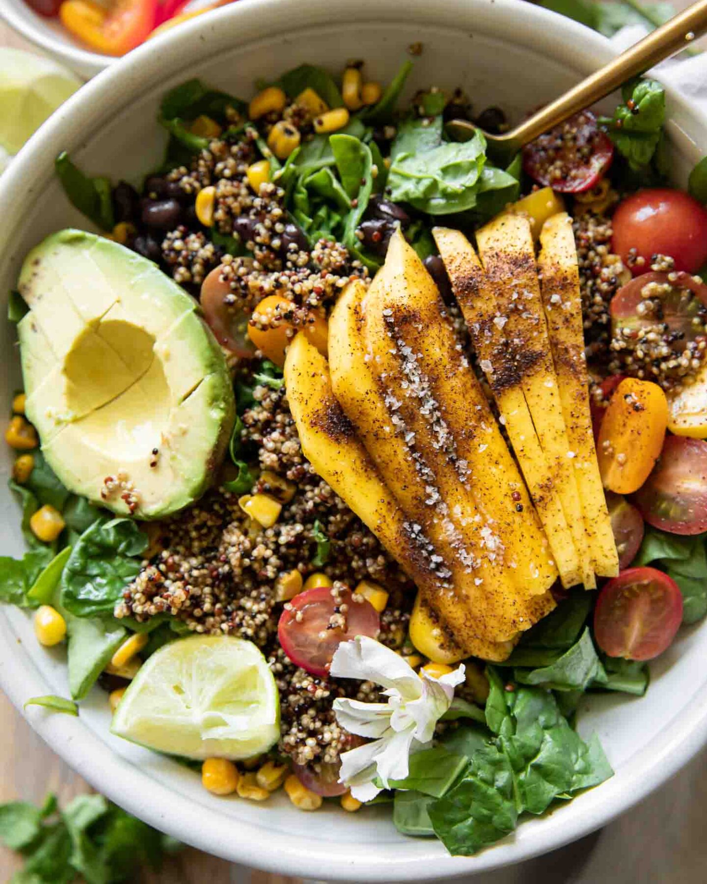 Chili Mango Zesty Quinoa Salad with fork and lime.
