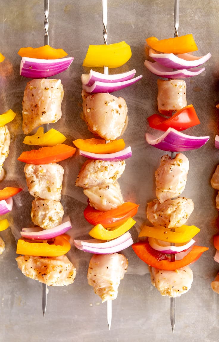 Chicken, bell peppers, and red onions on skewers.
