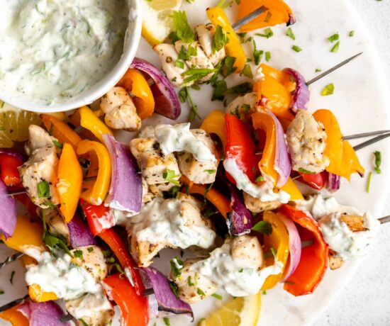 Greek Chicken Kabobs with tzatziki sauce on a platter.
