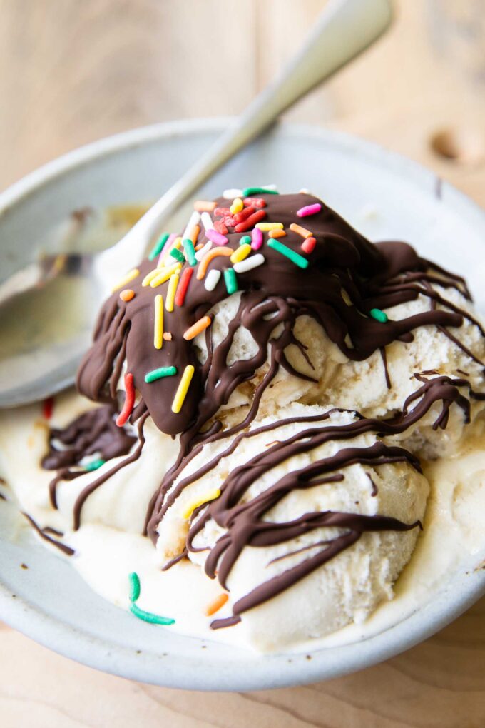 Homemade magic shell recipe drizzled over ice cream scoops.