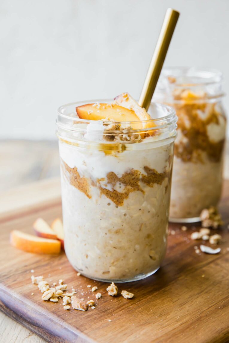 Peaches n’ Cream Overnight Oats in a mason jar with a spoon.
