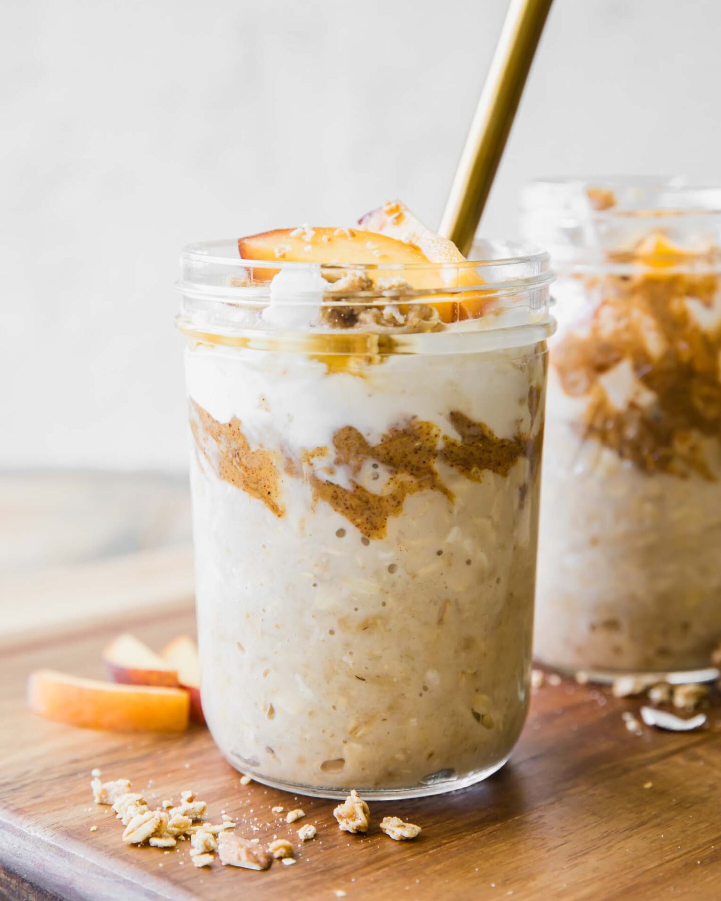 Peaches n’ Cream Overnight Oats recipe in a mason jar with a spoon.