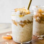 Peaches n’ Cream Overnight Oats recipe in a mason jar with a spoon.