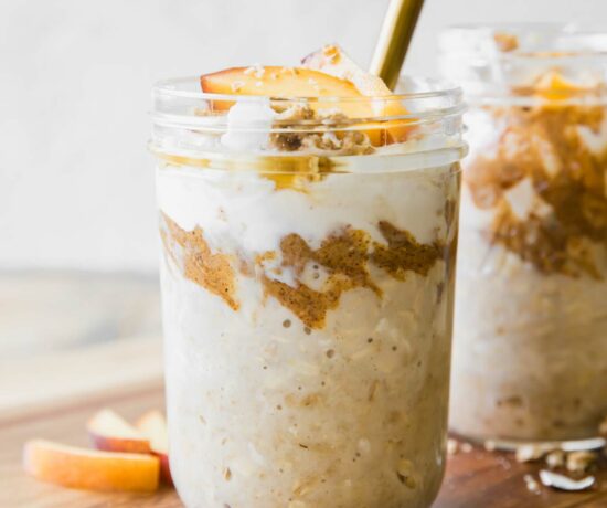 Peaches n’ Cream Overnight Oats recipe in a mason jar with a spoon.