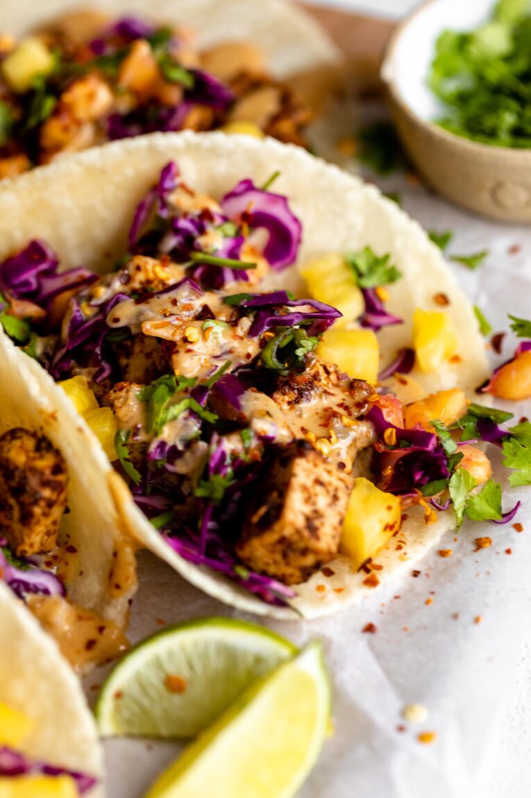 Angled photo of spicy Thai tofu taco with cabbage and pineapple.