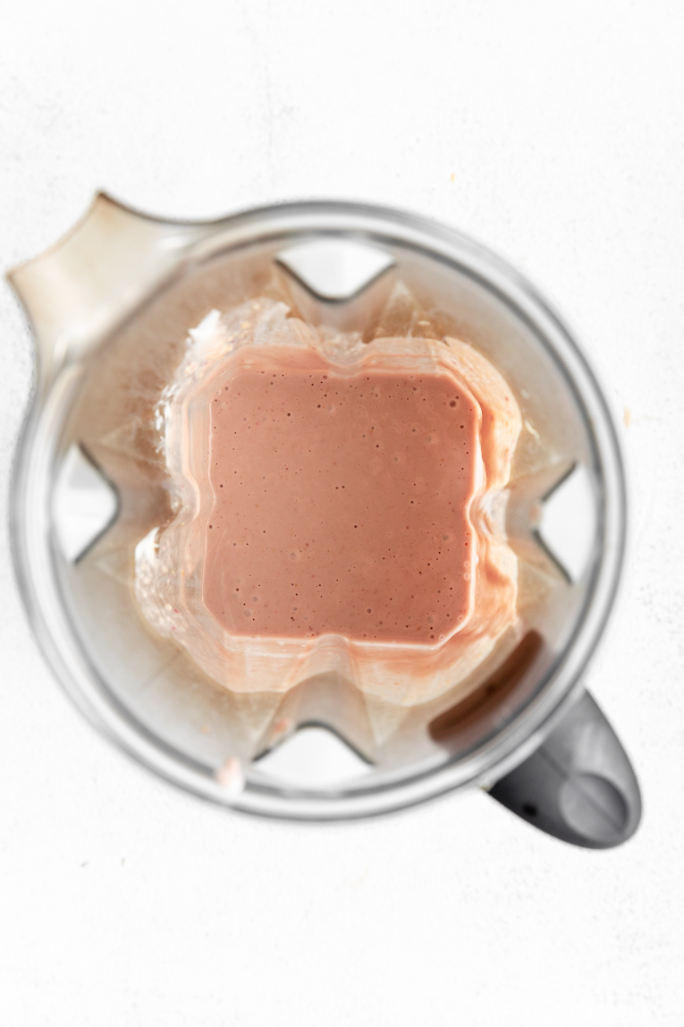 Healthy strawberry cheesecake filling in a blender.