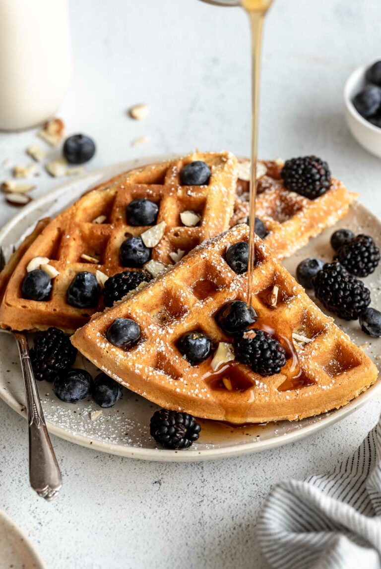 Syrup pouring over Almond Flour Waffles with fruit.