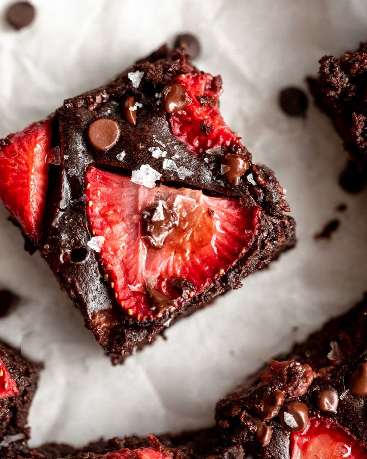 Top photo of chocolate brownie with strawberry slices.
