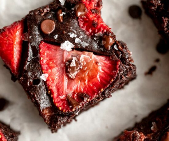 Top photo of chocolate brownie with strawberry slices.
