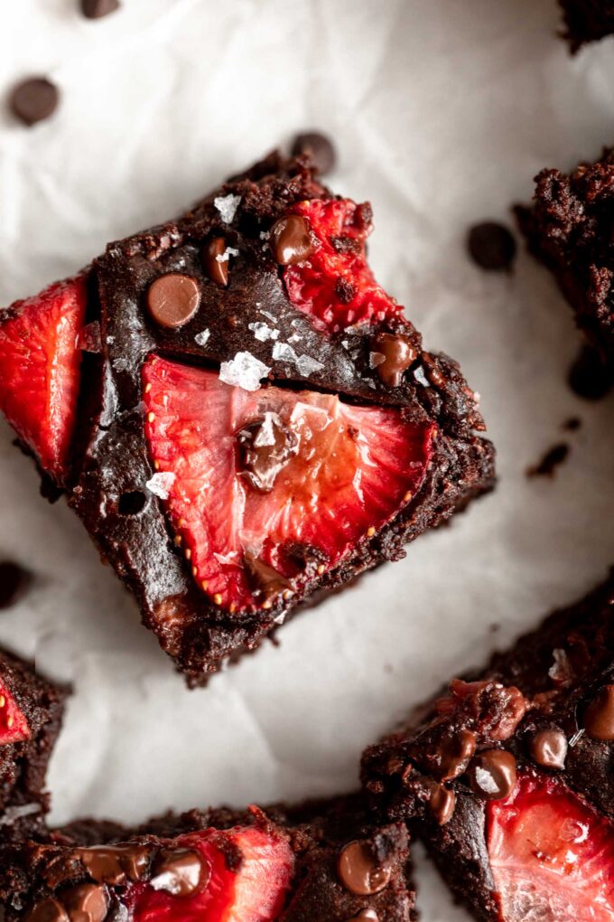 Top photo of chocolate brownie with strawberry slices.