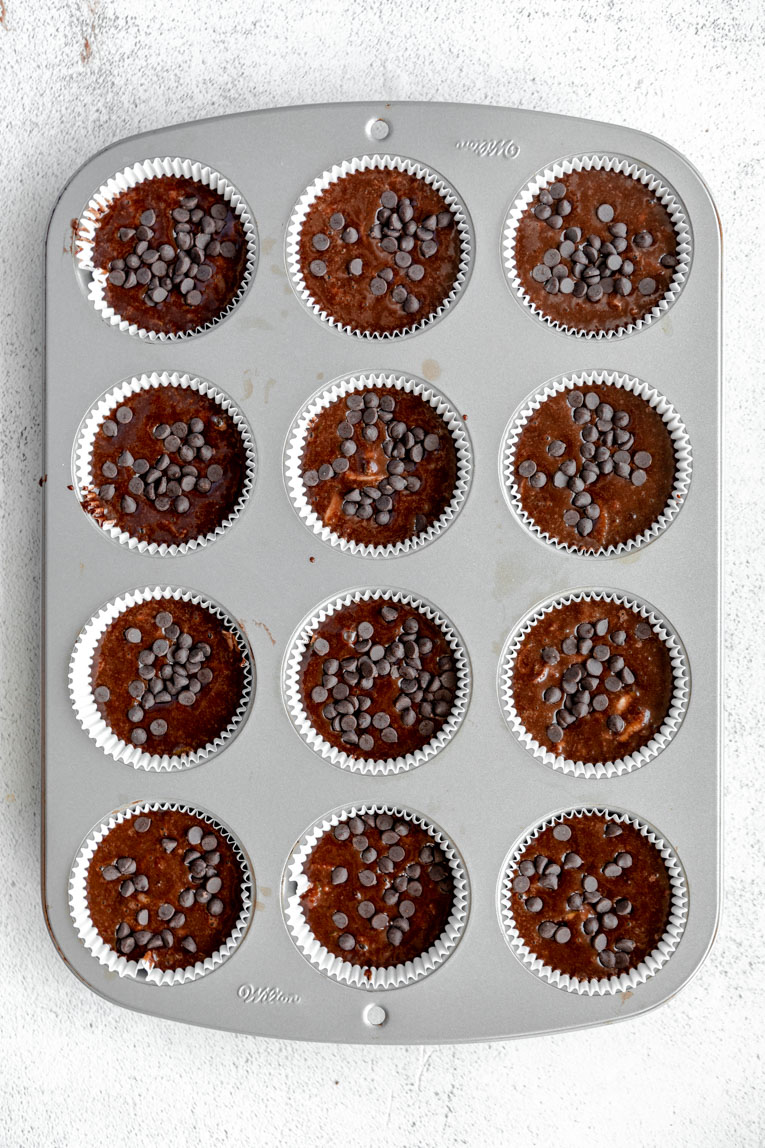 Chocolate zucchini muffins batter in muffin tin.