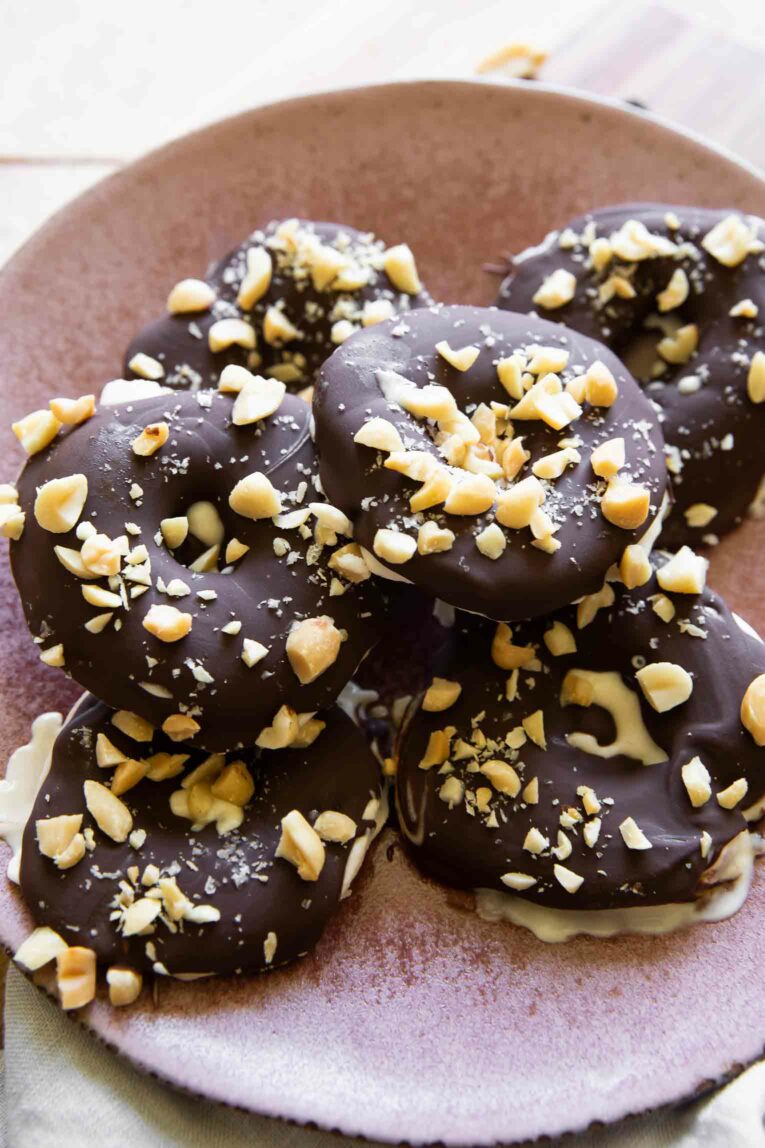 Angled photo of Chocolate Covered Apples with chopped peanuts and yogurt.