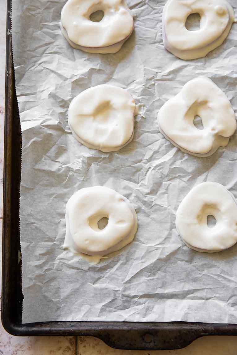 Apples coated in yogurt on a baking sheet.