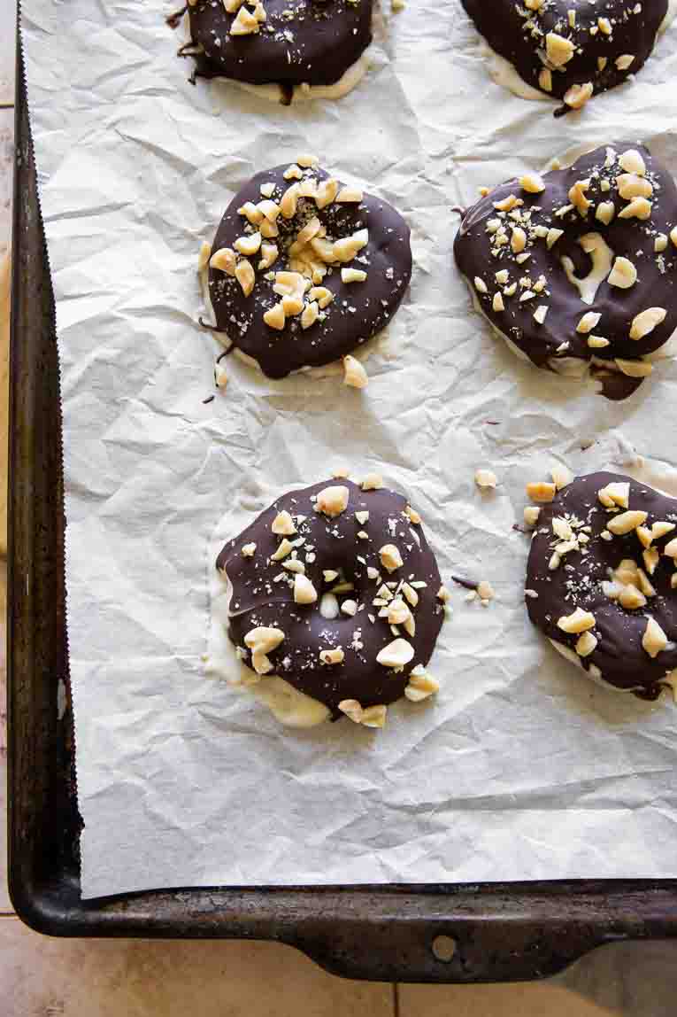 Chocolate covered apples with chopped peanuts.