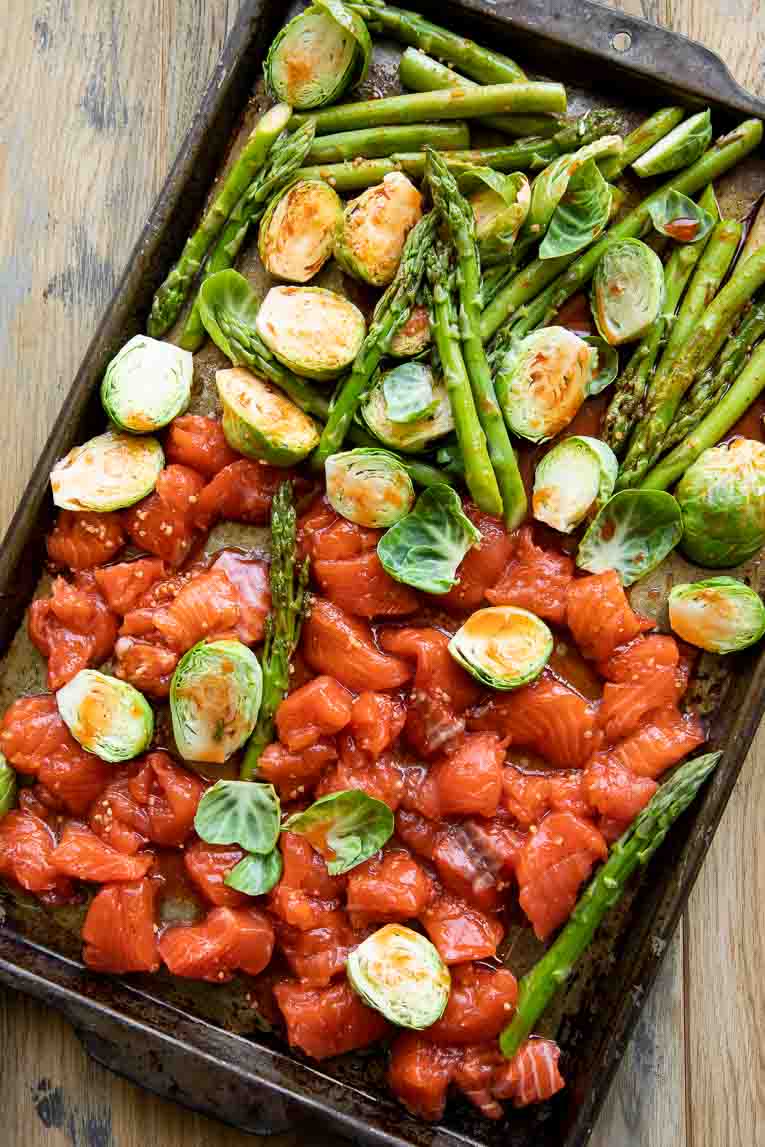 Hot honey salmon with brussels sprouts and asparagus on a sheet pan.