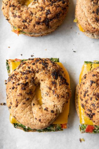 Close up of Meal Prep Breakfast Egg Bagel sandwiches on a baking sheet.